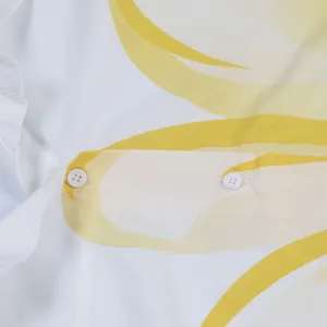 Close-up van de levendige gele bloemenprint en witte knopen op een stijlvol wit shirt