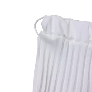 Vue détaillée de la jupe plissée blanche à taille haute montrant la texture du tissu et les plis