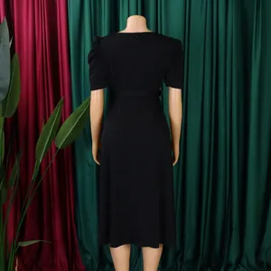 Elegant black midi dress with short puff sleeves and a waist tie shown from the back