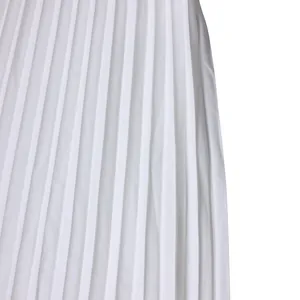Détail en gros plan montrant les plis couteaux verticaux d'un tissu de jupe midi blanche