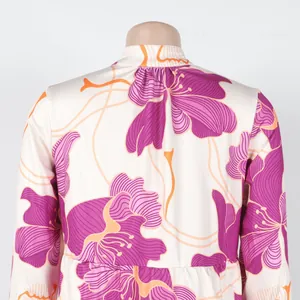 Detailed view of the purple and orange floral print on the back of a cream dress