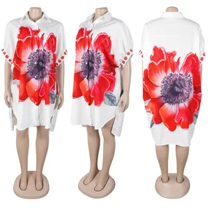 Detailweergaven van een witte hemdjurk met bloemenprint en asymmetrische zoomlijn