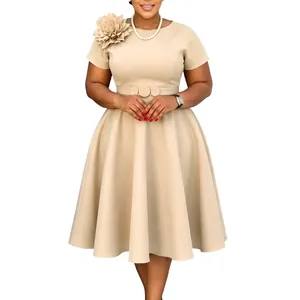 Gedetailleerd overzicht van de elegante beige grote maat jurk met 3D-bloem op de schouder.