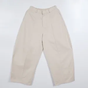 Front view of minimalist beige wide-leg trousers featuring an oversized silhouette.