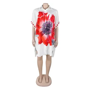 Detail van witte high-low hemdjurk met levendige rode bloemenprint en revers