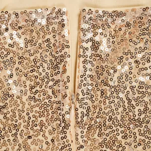 Nahaufnahme von funkelnden champagnergoldenen Pailletten und passendem Reißverschluss am Kleid