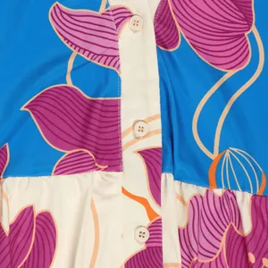 Close-up detail of floral print dress with button-down front and vibrant patterns