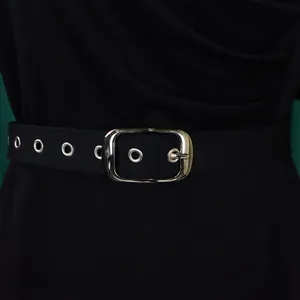 Close-up detail of an elegant black pleated dress featuring a stylish silver buckle belt.
