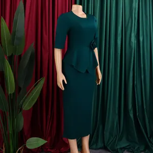 Detail eines eleganten dunkelgrünen Etuikleids mit Schößchen und 3D-Blumenakzent