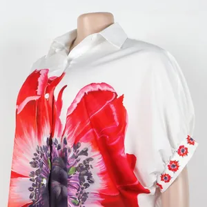 Elegante witte damesblouse met een grote rode klaproos bloemenprint en reverskraag