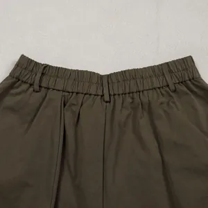Detail of the elasticated waistband and belt loops on dark olive commuter trousers.