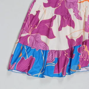 Close-up detail of purple floral print and ruffled blue hem on a stylish short dress