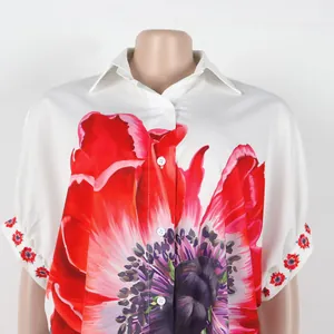 Gedetailleerd overzicht van het elegante witte shirt met een rode papaverbloemprint