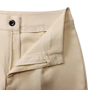 Dettaglio ravvicinato della vita di pantaloni beige con bottone nero e cerniera lampo
