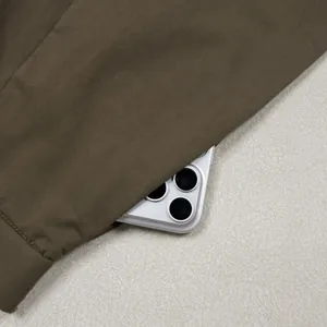 Detail shot of the spacious side pocket on olive brown loose-fit casual trousers