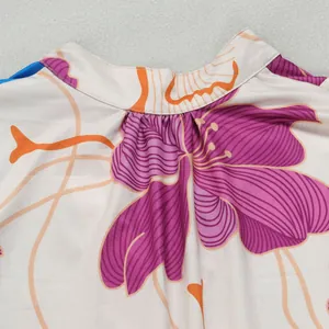 Close-up detail of elegant floral print and pleated neckline on color-block dress