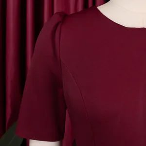 Close-up of burgundy dress featuring puff short sleeves and round neckline detail