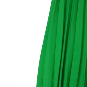 Gros plan sur la texture fine d'une jupe midi plissée d'un vert éclatant de qualité