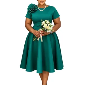 Elegante groene plus size jurk met bloemdecoratie op de schouder en wijde rok.