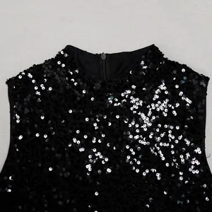 Detailed macro view of elegant black sequined mesh dress showing back zipper closure