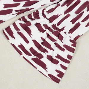 Κοντινή λεπτομέρεια από το μανίκι με βολάν και κομψό μπορντό τύπωμα με πινελιές σε λευκό.