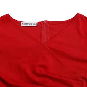 Close-up detail of a red V-neck dress with elegant pleated design and back zipper.