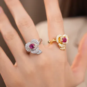 Close-up detail of 14k gold plated flower rings with red zircon center stones and pave gems