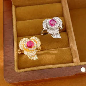 Detailed view of 14k gold plated flower rings with red zircon center in jewelry box.