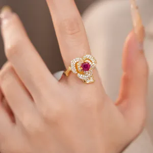Close-up of 14k gold-plated flower ring with ruby red zircon and sparkling accents