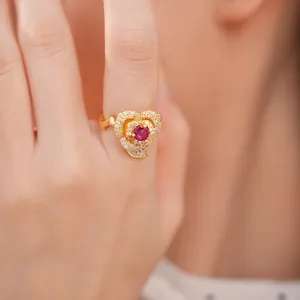 Detailed close-up of 14k gold plated flower ring with red stone and pavé zircons