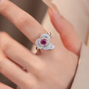 Macro view of a flower ring with a red gemstone and sparkling white zircons