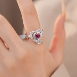 Detailed macro view of elegant 14k gold plated flower ring with red zircon stone on finger