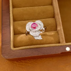 Close-up of elegant zircon flower ring with a red center stone in a velvet jewelry box