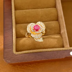 Close-up of an elegant 14k gold plated flower ring featuring a red gemstone detail.