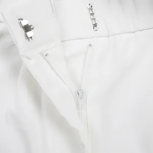 Vue macro d'une combinaison blanche avec fermeture éclair et crochet métallique