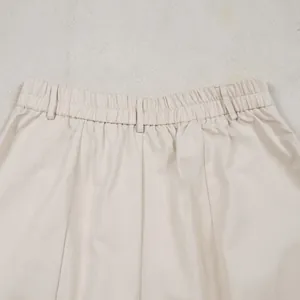 Close-up detail of elastic waist and belt loops on beige commute casual trousers