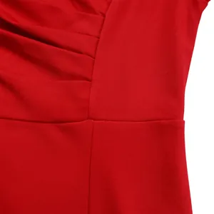 Close-up detail of red pleated V-neck dress showing fabric texture and fine stitching.