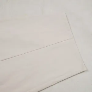 Detail showing the clean stitching and hem of beige loose commuter casual pants