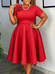 Elegante rode plus size swingjurk met bloemendetail op de schouder en een ceintuur