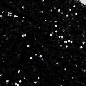 Macro photography detail of black shimmering sequins stitched on premium mesh fabric