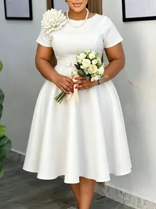 Elegante witte plus size swingjurk met een grote 3D-bloemdecoratie op de schouder
