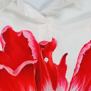 Detailopname van de levendige rode bloemenprint en witte knopen op het witte shirt