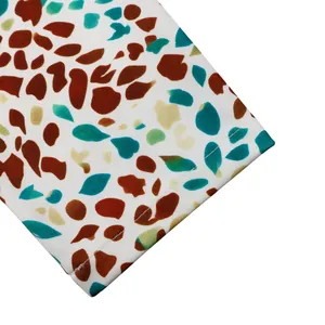Primo piano del motivo astratto a ciottoli colorati e cuciture su tessuto bianco da abito