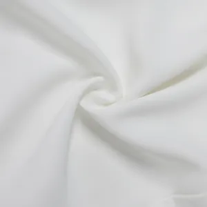 Gros plan montrant la texture fine et les plis en spirale du tissu blanc de la combi