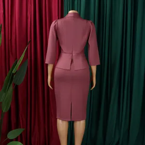 Vista posteriore di un elegante abito da ufficio rosa cipria con maniche a 3/4 e spacco.