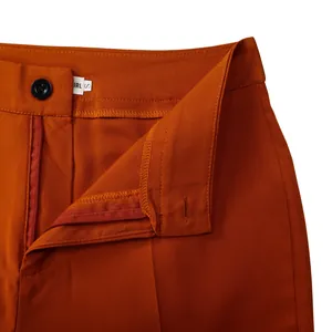Primo piano dettagliato della cintura e della cerniera di un pantalone da completo arancione