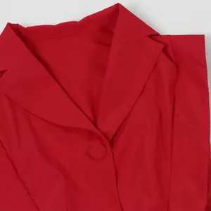 Detailaufnahme eines roten Freizeit-Jumpsuits mit V-Ausschnitt, Revers und Knopf.