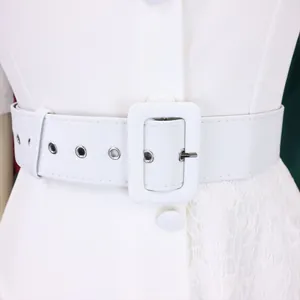 Detail view of white high-waisted dress featuring a wide belt and delicate lace stitching