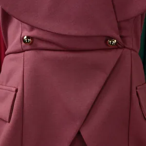 Primo piano di un elegante abito rosa scuro con bottoni dorati e design del risvolto.