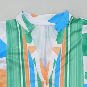 Close-up detail of V-neck collar on geometric color block print dress with button